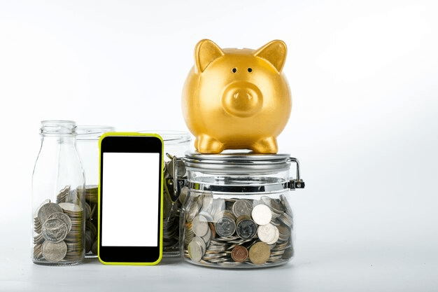 A piggy bank, phone and coins inside the bottle